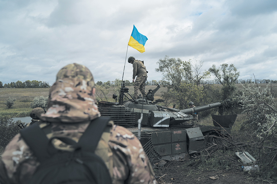 Des membres de la garde nationale de l’Ukraine face à un char ennemi détruit non loin de la frontière avec la Russie, dans la région de Kharkiv en plein reconquête, 19 septembre 2022 © Leo Correa/AP/SIPA